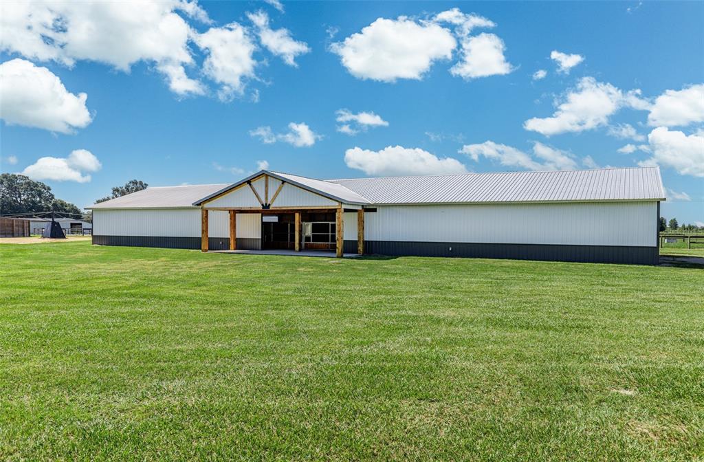 A long, single-story metal building with a covered entrance sits on a grassy field — 1285 NW 102ND A BOULEVARD, WILDWOOD, FL