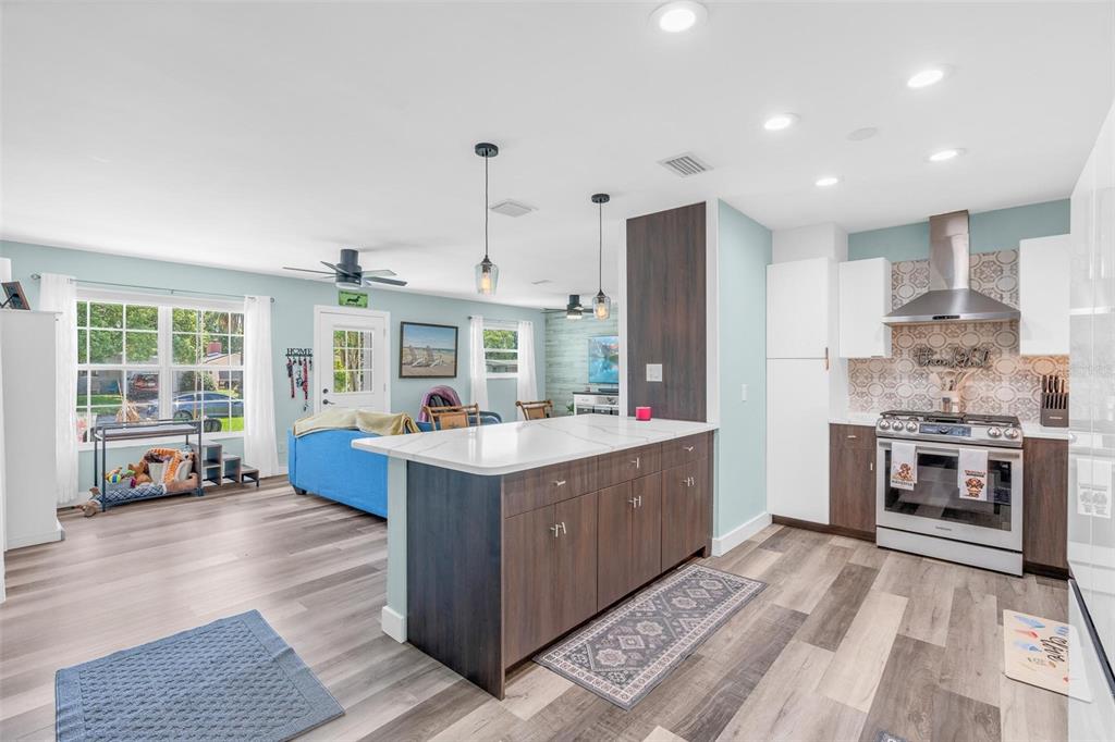A kitchen with a white marble island and dark wood cabinets opens into a living area — 2824 OAK LEA DRIVE, SOUTH DAYTONA, FL