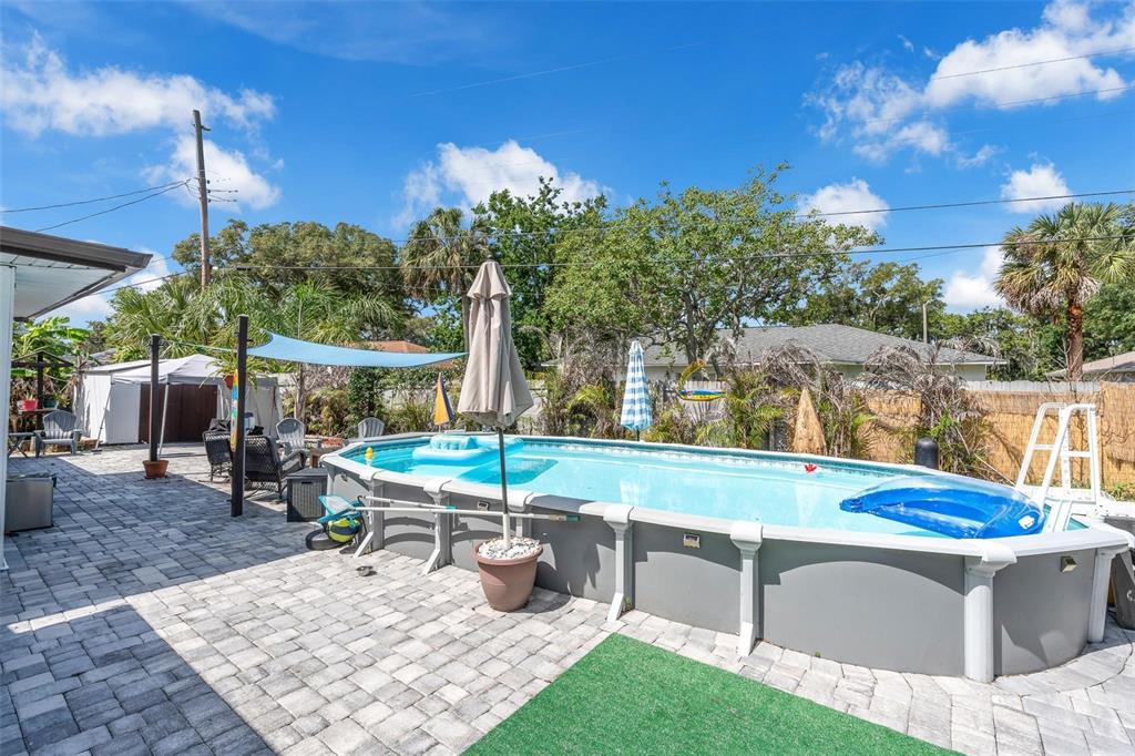 An above-ground swimming pool sits on a paved patio in a fenced backyard — 2824 OAK LEA DRIVE, SOUTH DAYTONA, FL