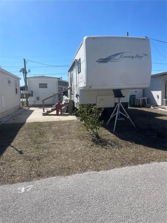 A Kountry Star fifth-wheel trailer is parked on a lot with a small wooden staircase — 37 ILLINOIS STREET, PALMETTO, FL