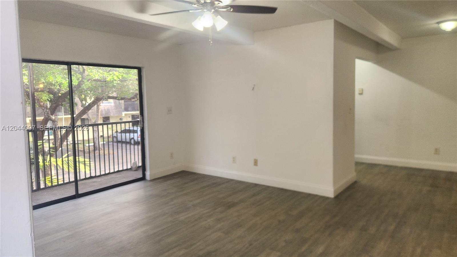 An empty room with wood-look flooring, a ceiling fan, and a sliding glass balcony door — 1045 S Flagler Ave # 716, Pompano Beach FL 33060, POMPANO BEACH, FL