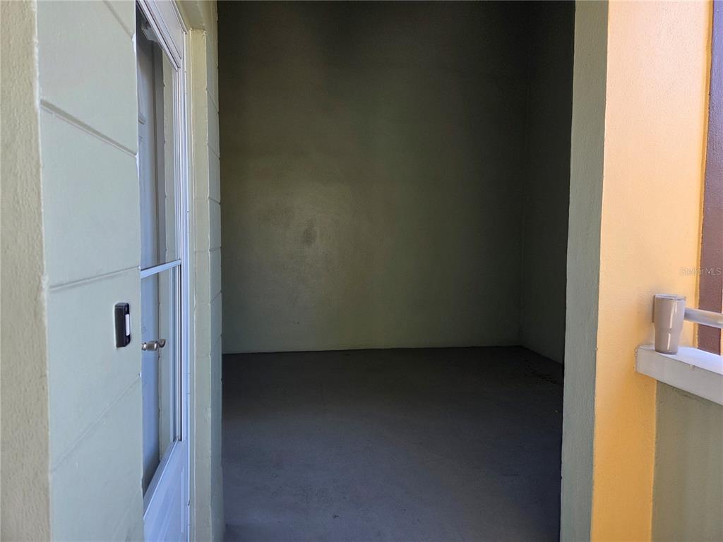 A view looking into a small, empty storage room with concrete floors and plain walls — 2448 COLUMBIA DRIVE UNIT 72, CLEARWATER, FL