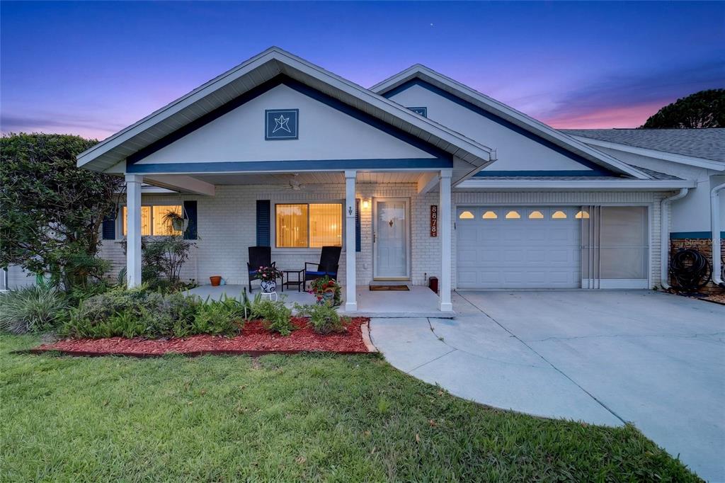 A single-story house with a white brick exterior, a front porch, and an attached garage — 8878 SW 90TH LANE N UNIT B, OCALA, FL