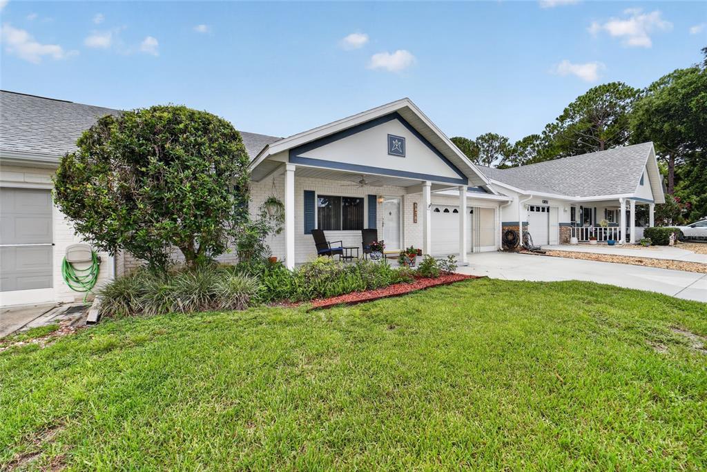 A single-story house with a white brick exterior, a covered porch, and a green lawn — 8878 SW 90TH LANE N UNIT B, OCALA, FL