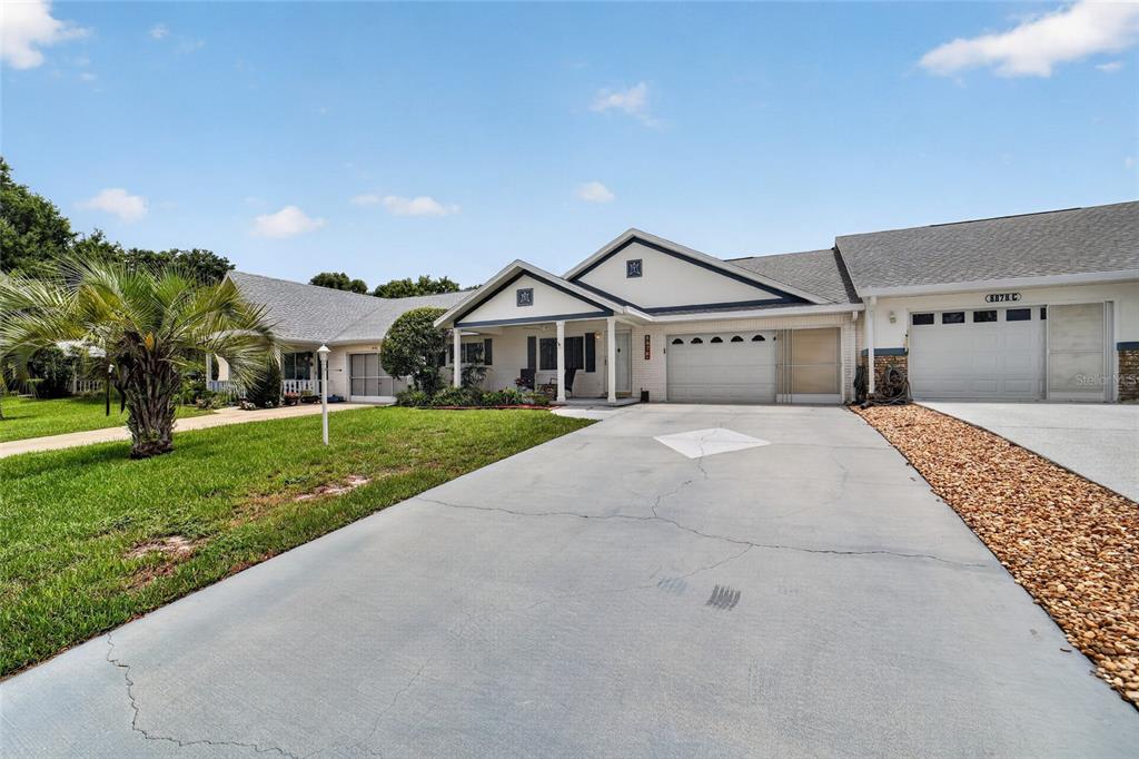 A single-story house with a white facade, two garage doors, and a concrete driveway — 8878 SW 90TH LANE N UNIT B, OCALA, FL