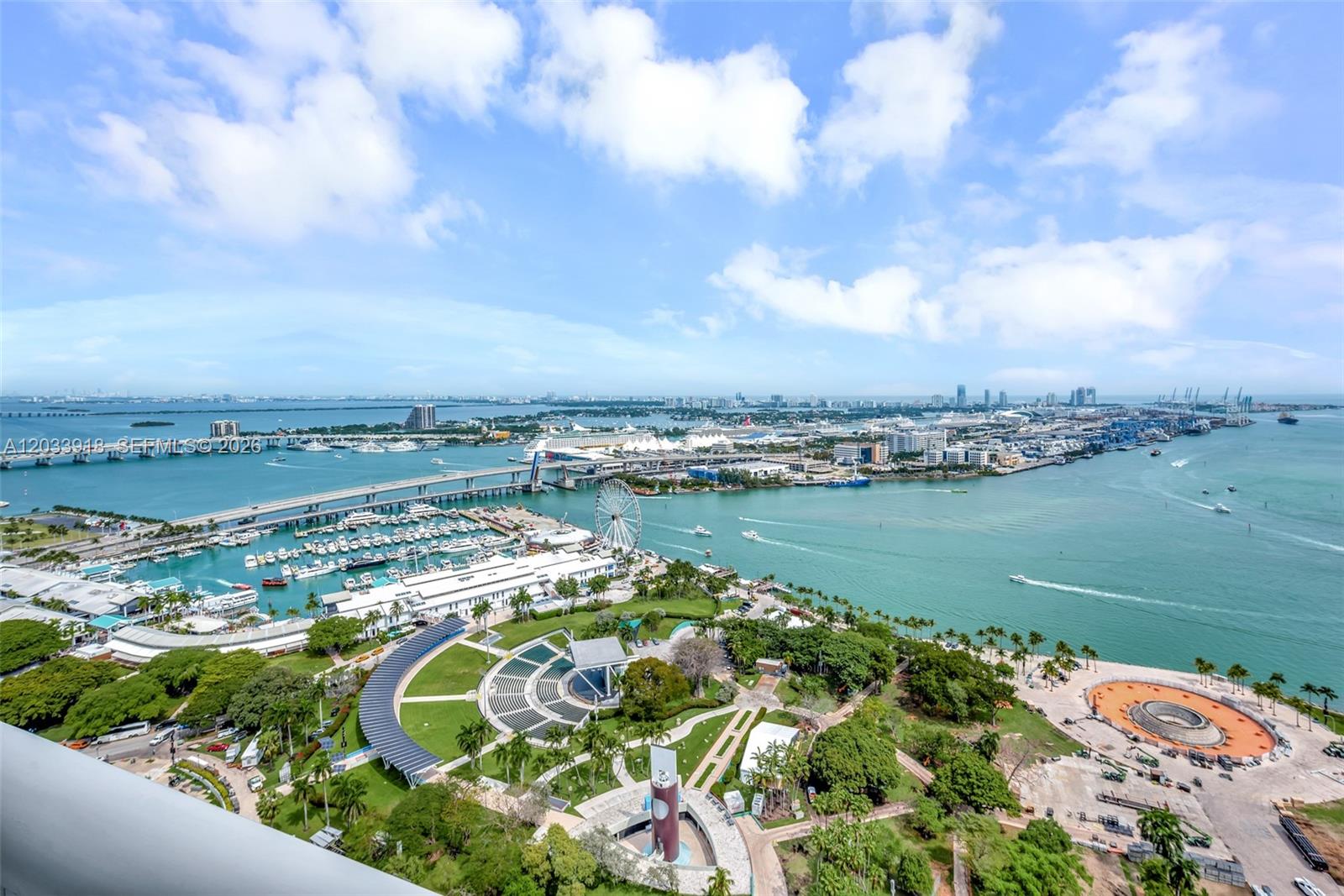 An aerial view shows a park with an amphitheater, a marina, and a bridge in Miami — 50 Biscayne Blvd # 3802, Miami FL 33132, MIAMI, FL