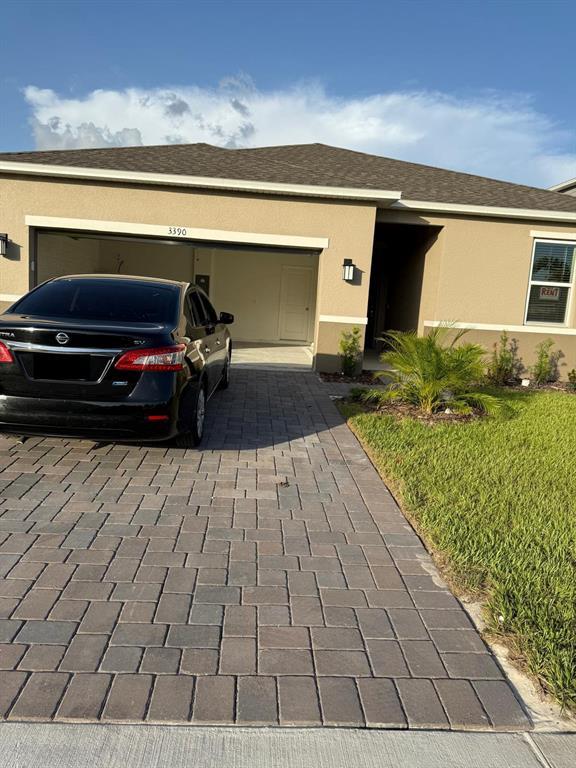 A single-story house with a paved driveway, a black sedan, and a tan exterior — 3390 SANCTUARY DRIVE, CLERMONT, FL