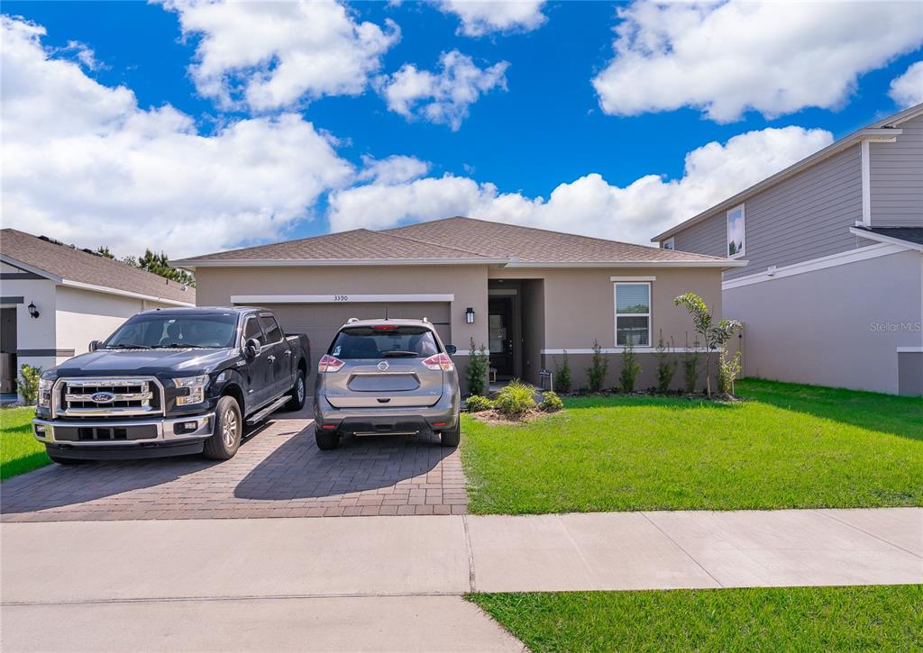 A single-story house with a two-car garage and two vehicles parked in the driveway — 3390 SANCTUARY DRIVE, CLERMONT, FL