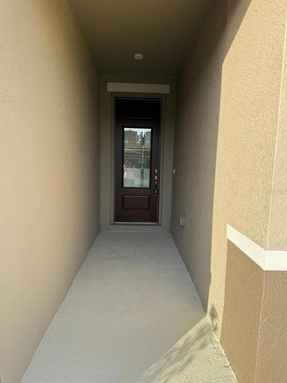 A recessed entryway features a dark brown front door with a glass panel — 3390 SANCTUARY DRIVE, CLERMONT, FL