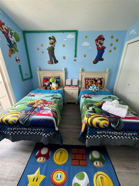 A bedroom features two twin beds with Mario Kart bedding and themed wall decals — 121 BLOOMINGDALE DRIVE, DAVENPORT, FL