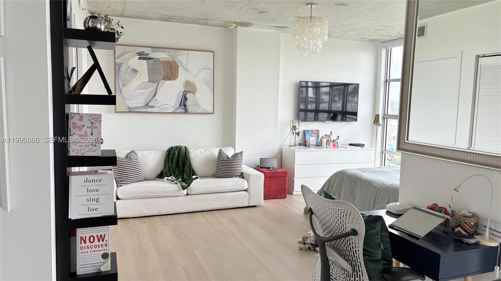 A studio apartment features a white sofa, a bed, a desk, and a television — 3451 NE 1st Ave # M0703, Miami FL 33137, MIAMI, FL