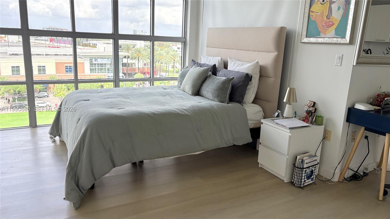 A bedroom features a bed with a light-colored headboard, a nightstand, and large windows — 3451 NE 1st Ave # M0703, Miami FL 33137, MIAMI, FL