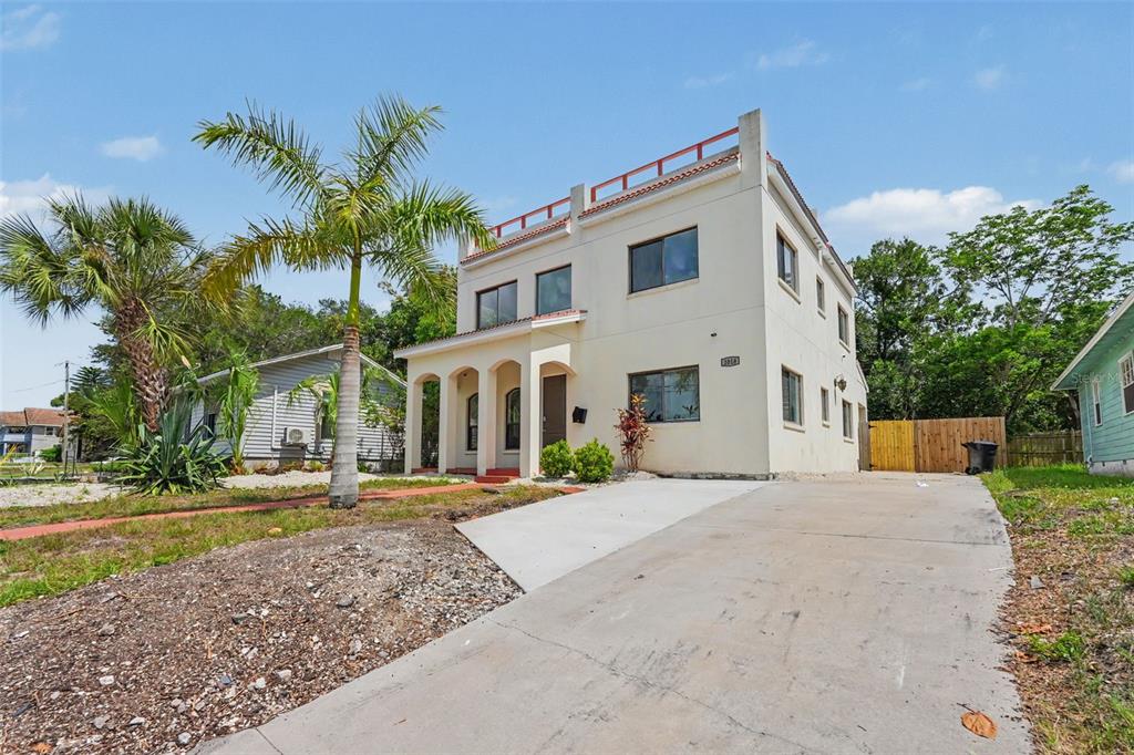 A two-story stucco house with a flat roof deck and a concrete driveway — 1018 7TH AVENUE S, ST PETERSBURG, FL
