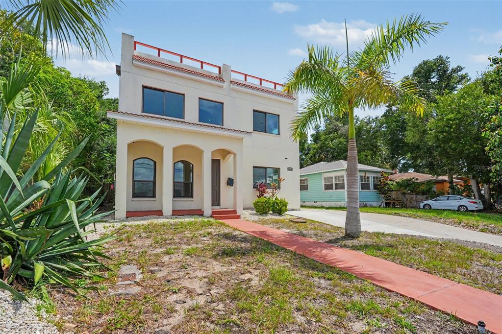 A two-story stucco house with a flat roof deck and a red walkway — 1018 7TH AVENUE S, ST PETERSBURG, FL