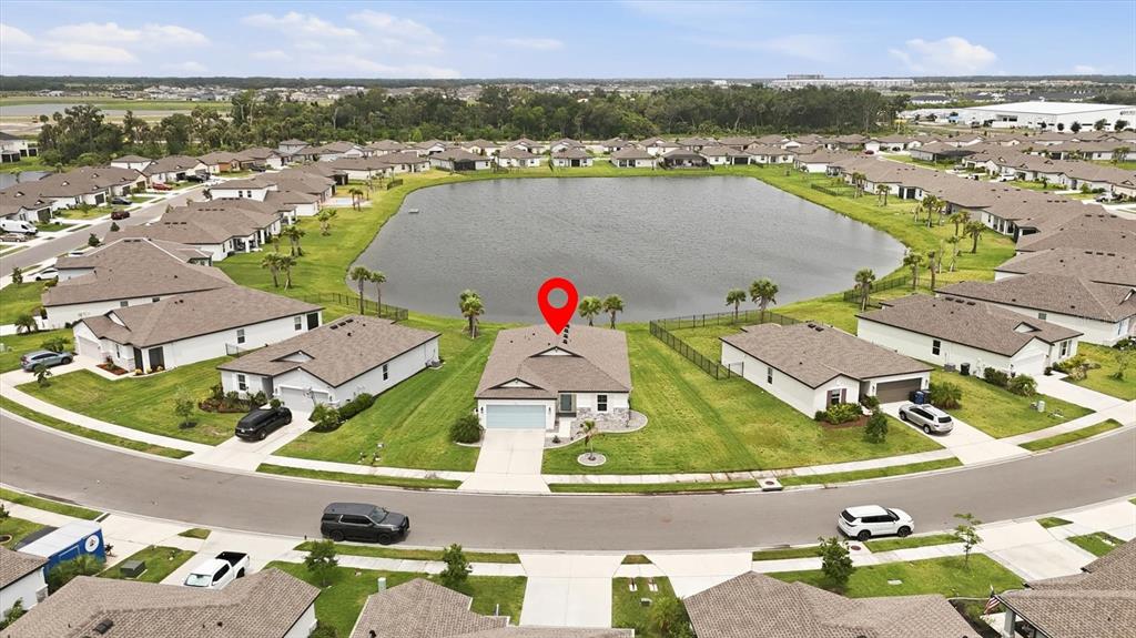 An aerial view shows a single-family house with a red location pin by a lake — 9959 LAST LIGHT GLEN, PARRISH, FL