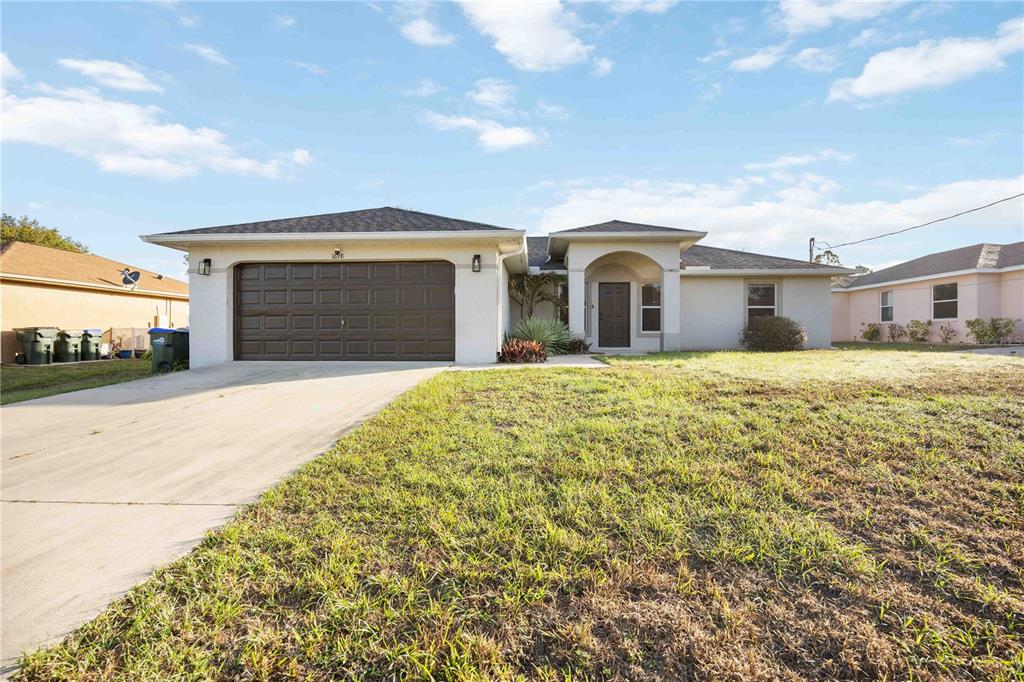 A single-story house with a brown garage door, arched entryway, and a concrete driveway — 1698 N LAVINA STREET, NORTH PORT, FL