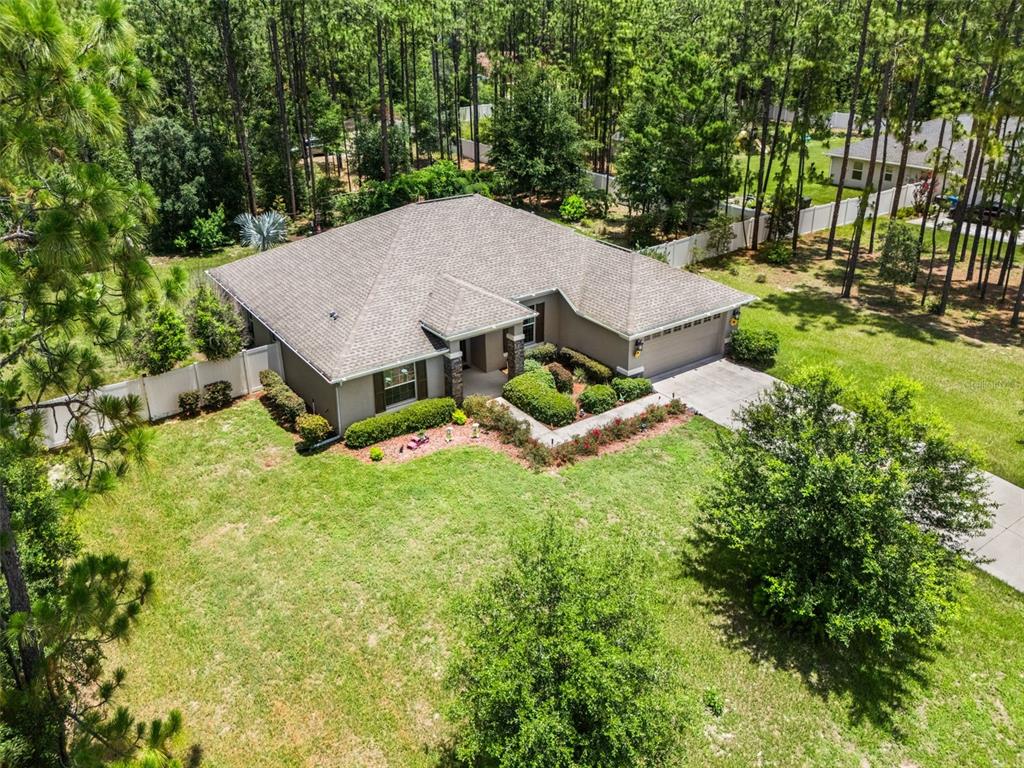 An aerial view of a single-story house with a gray roof and a large lawn — 15577 SAGO DRIVE, BROOKSVILLE, FL