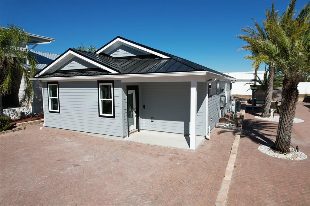 A light gray house with a black metal roof and a covered front porch — 2253 ST GEORGE DRIVE, DAVENPORT, FL