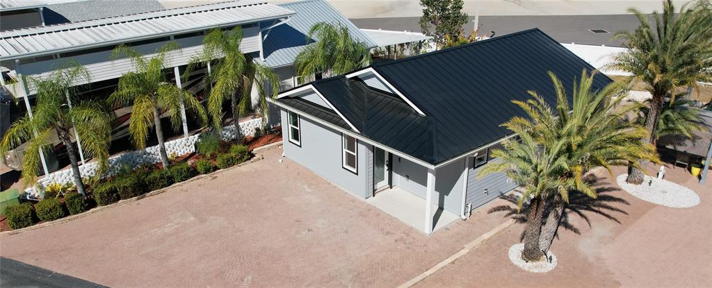An aerial view shows a light gray house with a black metal roof and palm trees — 2253 ST GEORGE DRIVE, DAVENPORT, FL