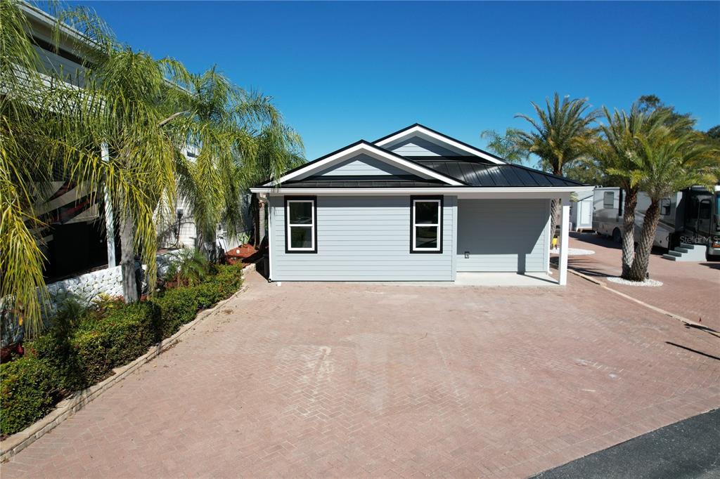 A light blue single-story house with a black metal roof and a paved driveway — 2253 ST GEORGE DRIVE, DAVENPORT, FL