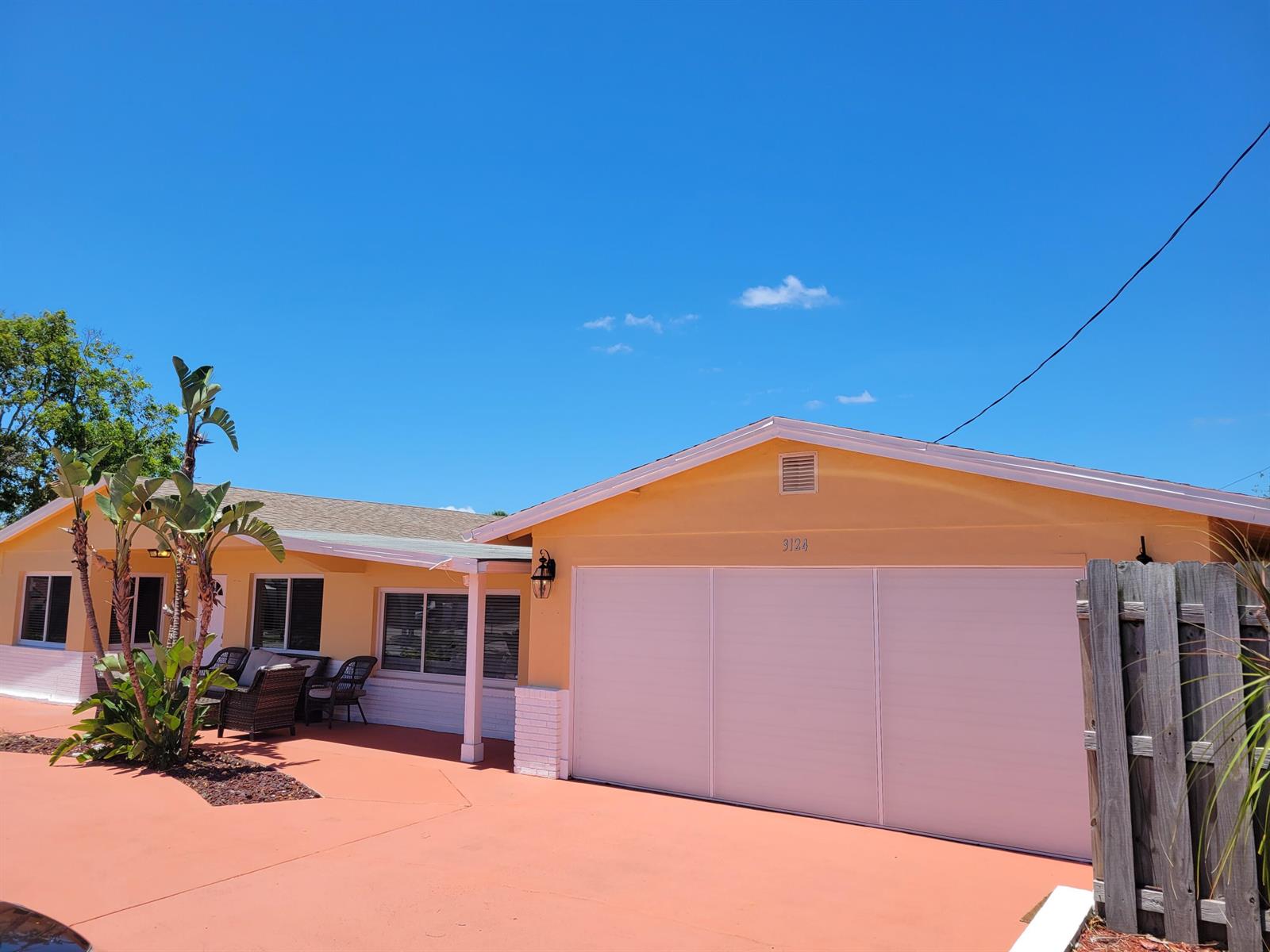 A yellow house with a white garage door and a red concrete driveway — 3124 NE Skyline Drive # B, Jensen Beach FL 34957, JENSEN BEACH, FL