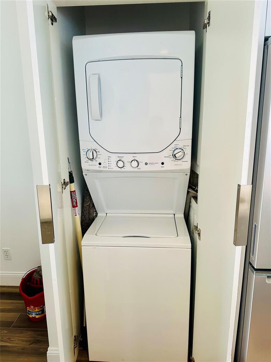 A white stacked washer and dryer unit sits inside a closet in a laundry area — 8142 NW 17th Manor, Plantation FL 33322, PLANTATION, FL