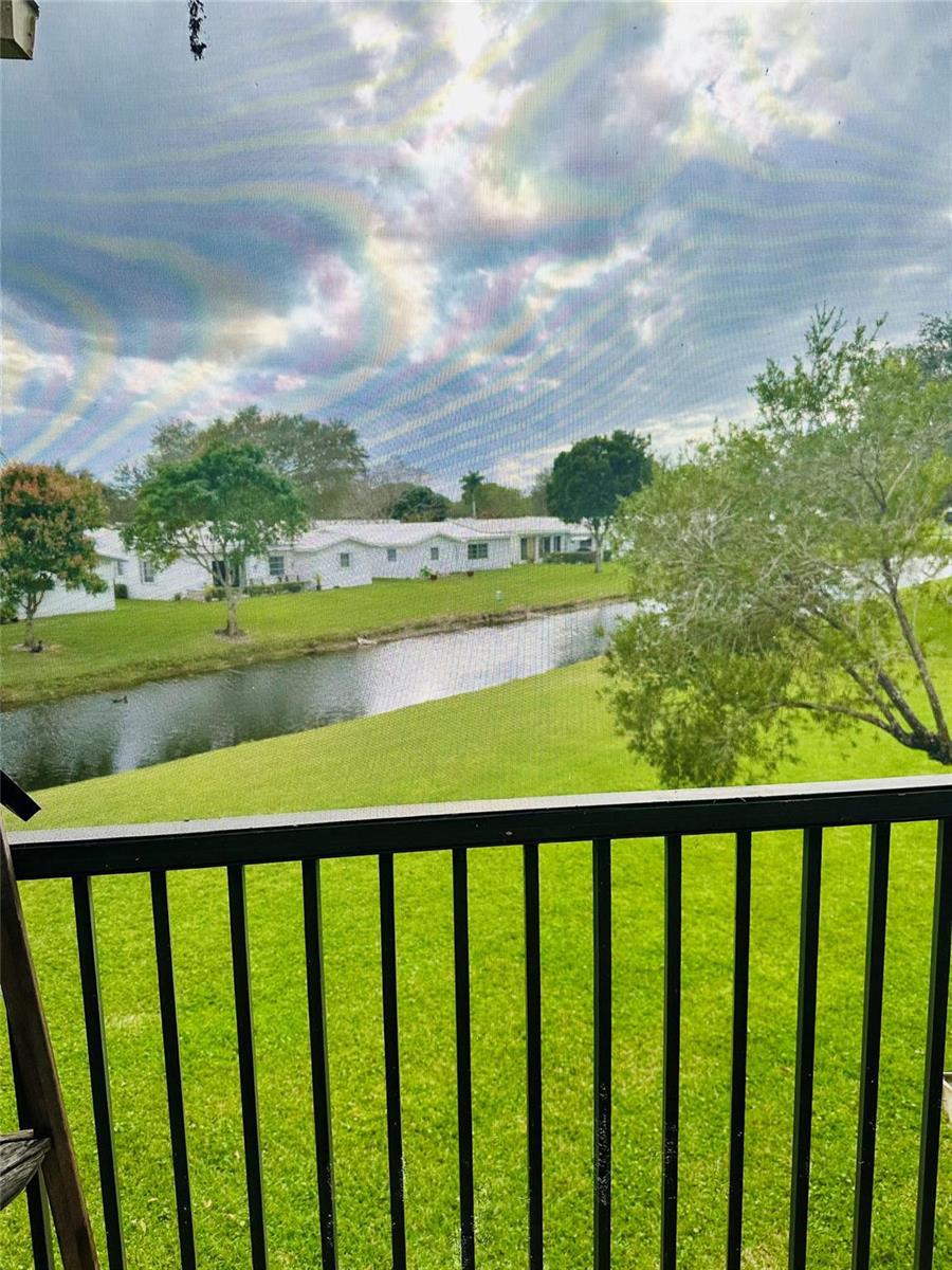 A view of a canal and white houses from a balcony with a black railing — 8142 NW 17th Manor, Plantation FL 33322, PLANTATION, FL