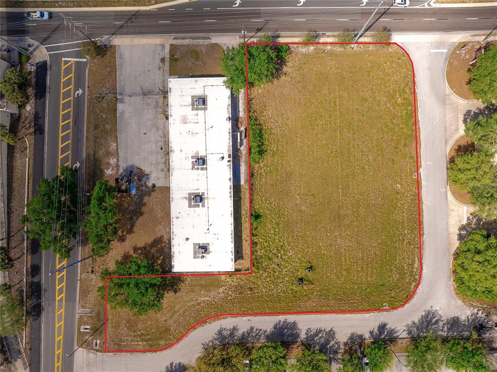An aerial view shows a rectangular building and an adjacent vacant lot outlined in red — 0 OLYMPIAN WAY, WINTER HAVEN, FL