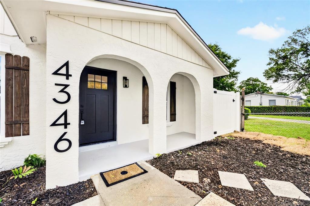 A white stucco house exterior features a black front door and arched entryway — 4346 DAUBERT STREET, ORLANDO, FL