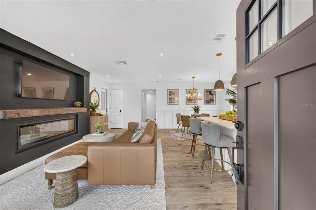 A view from an open doorway into a living room with a fireplace and kitchen — 4346 DAUBERT STREET, ORLANDO, FL