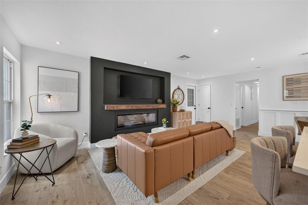 A living room features a black accent wall with a fireplace, television, and leather sofa — 4346 DAUBERT STREET, ORLANDO, FL
