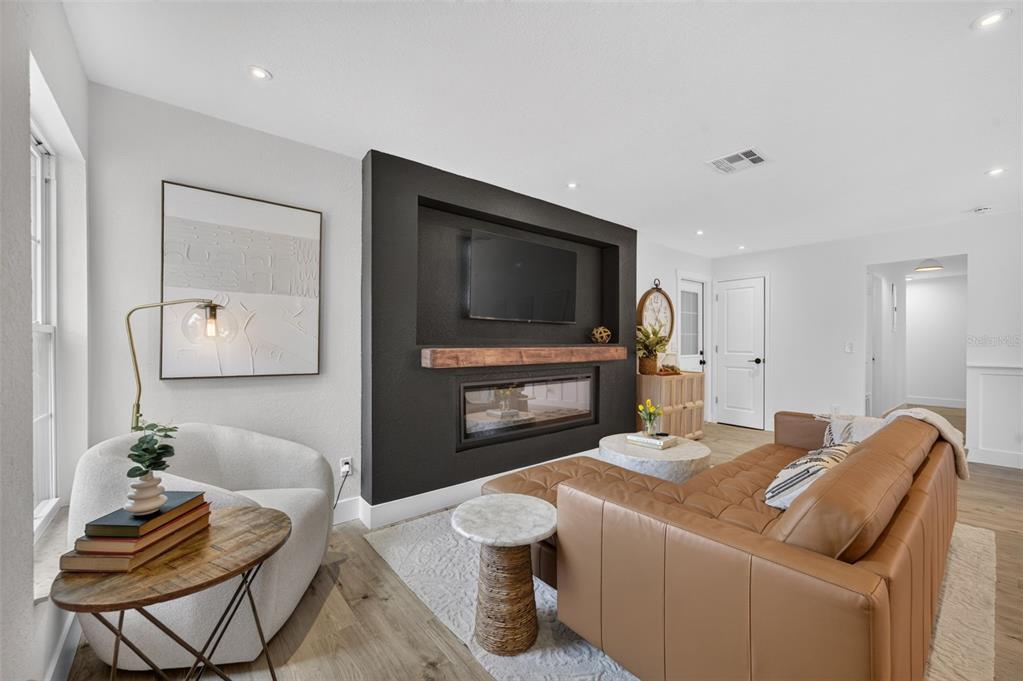 A living room features a black accent wall with a built-in television and fireplace — 4346 DAUBERT STREET, ORLANDO, FL