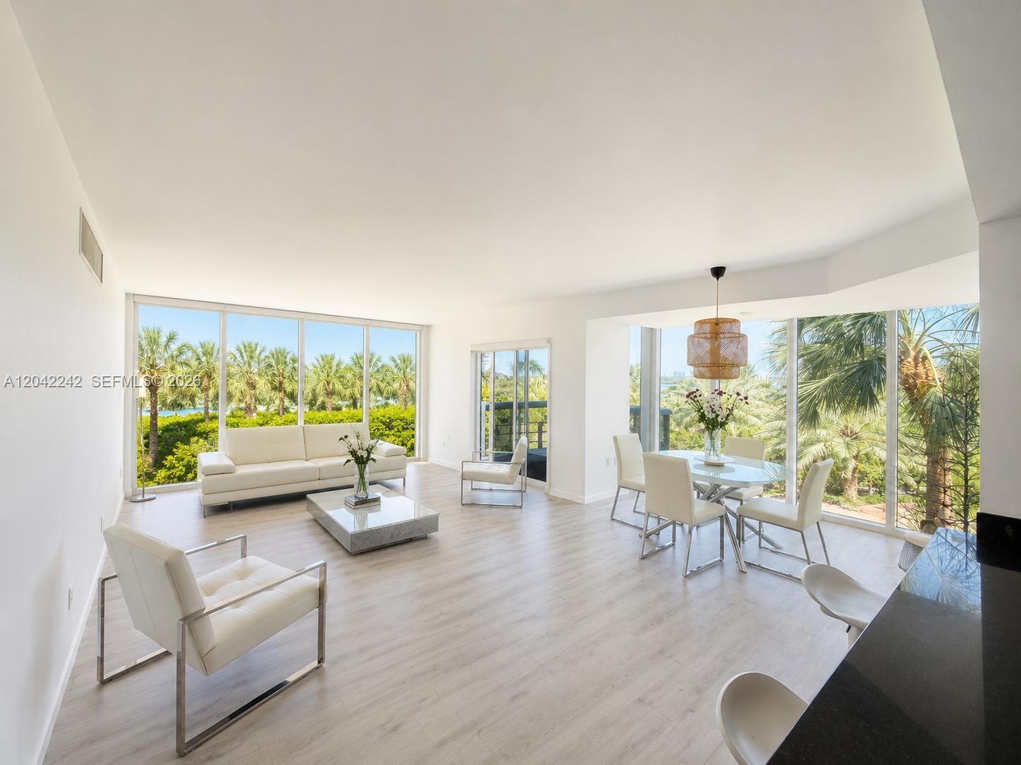 A bright, open-concept living and dining area features white furniture, light wood flooring, and floor-to-ceiling windows — 10275 Collins Ave # 431, Bal Harbour FL 33154, BAL HARBOUR, FL