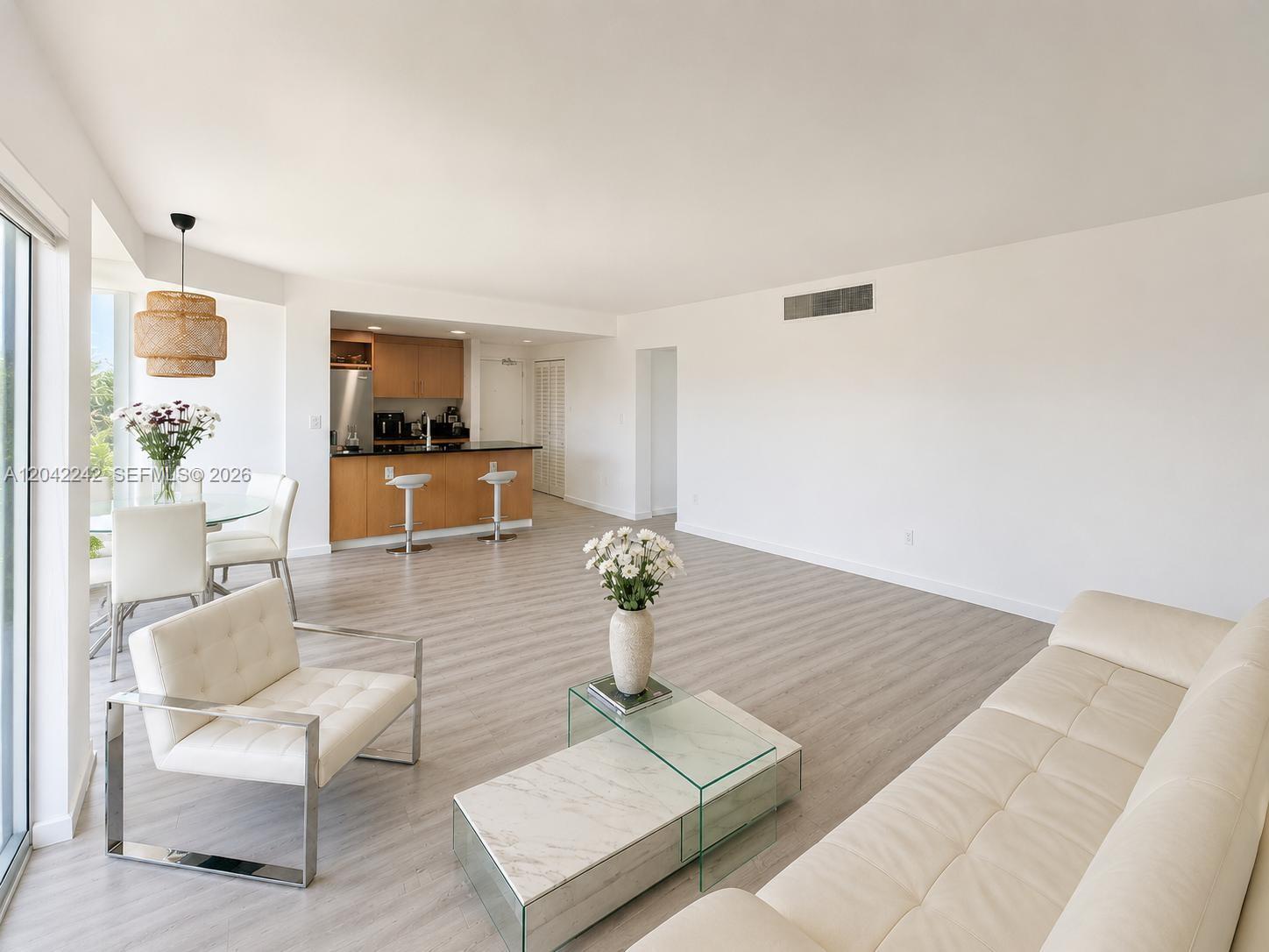 This open-concept living and dining area features light wood-look flooring and a modern kitchen — 10275 Collins Ave # 431, Bal Harbour FL 33154, BAL HARBOUR, FL