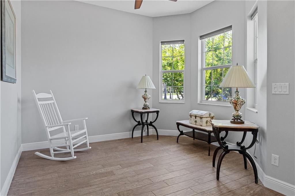 A room with light gray walls, wood-look tile flooring, a white rocking chair, and two lamps — SEBASTIAN, FL
