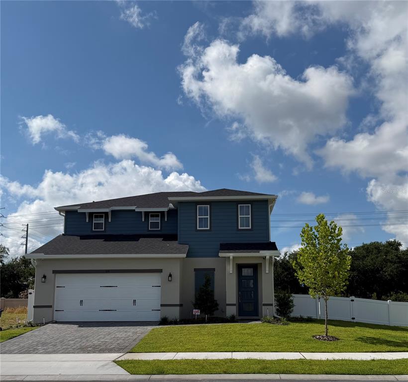 A two-story house with a two-car garage, blue siding, and a paved driveway — 292 ELENA LAVIN CIRCLE, ORLANDO, FL