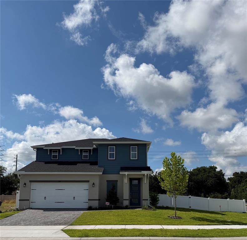 A two-story house with a blue upper level, tan lower level, and a two-car garage — 292 ELENA LAVIN CIRCLE, ORLANDO, FL