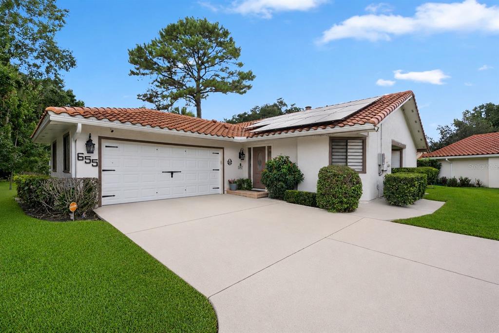 A single-story house with a white stucco exterior, tile roof, and a two-car garage — 655 NIGHTHAWK CIRCLE, WINTER SPRINGS, FL