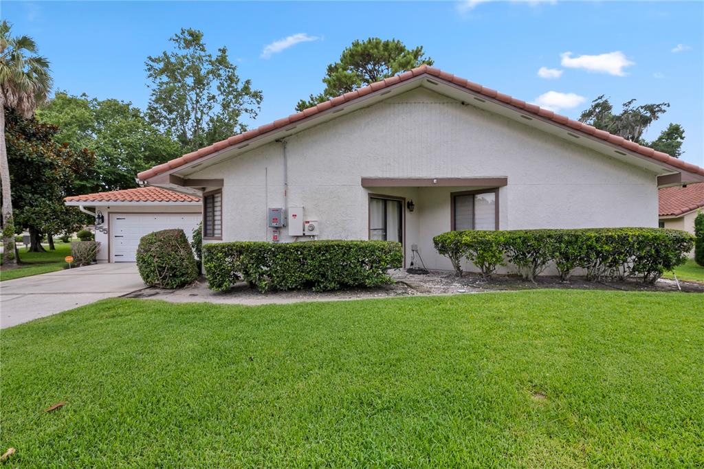 A single-story house with a white stucco exterior, a tiled roof, and a front lawn — 655 NIGHTHAWK CIRCLE, WINTER SPRINGS, FL