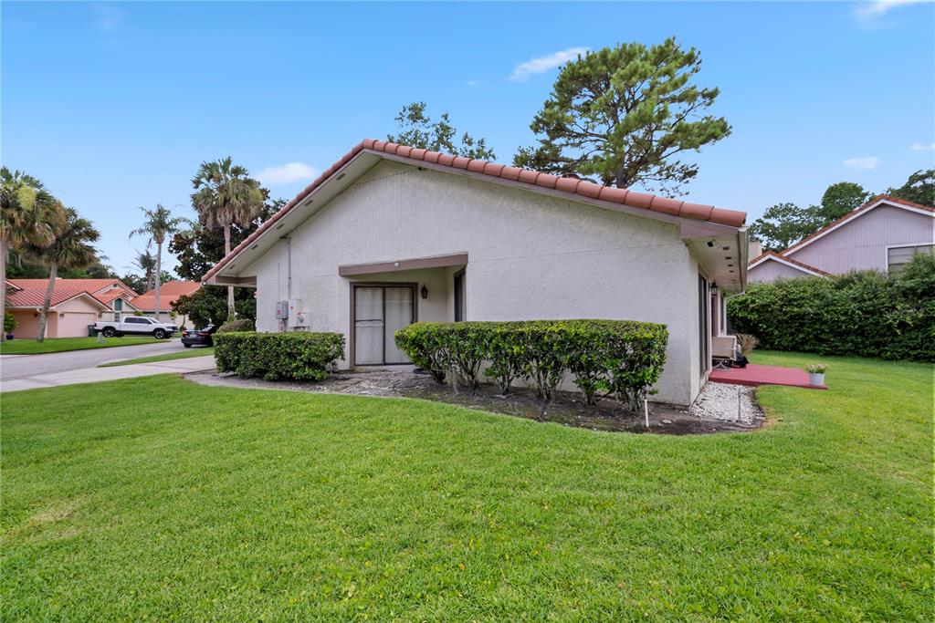 The exterior of a white stucco house features a red tile roof and sliding doors — 655 NIGHTHAWK CIRCLE, WINTER SPRINGS, FL
