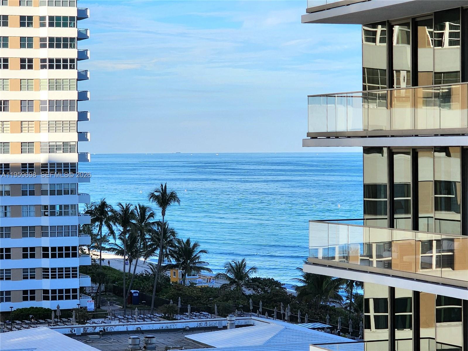 An exterior view shows the ocean framed by two high-rise apartment buildings with balconies — 2030 S Ocean Dr # 823, Hallandale Beach FL 33009, HALLANDALE BEACH, FL