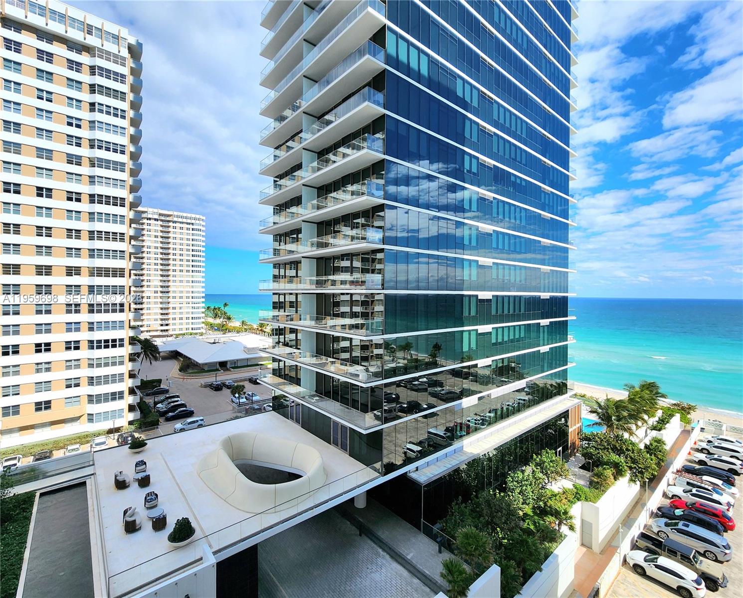 An exterior view of a modern glass high-rise building next to the ocean — 2030 S Ocean Dr # 823, Hallandale Beach FL 33009, HALLANDALE BEACH, FL