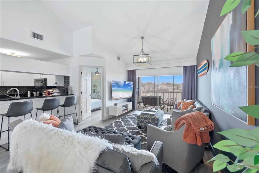 A screened-in porch overlooks a lake with houses in the distance — 972 SANDPIPER CIRCLE UNIT 972, BRADENTON, FL