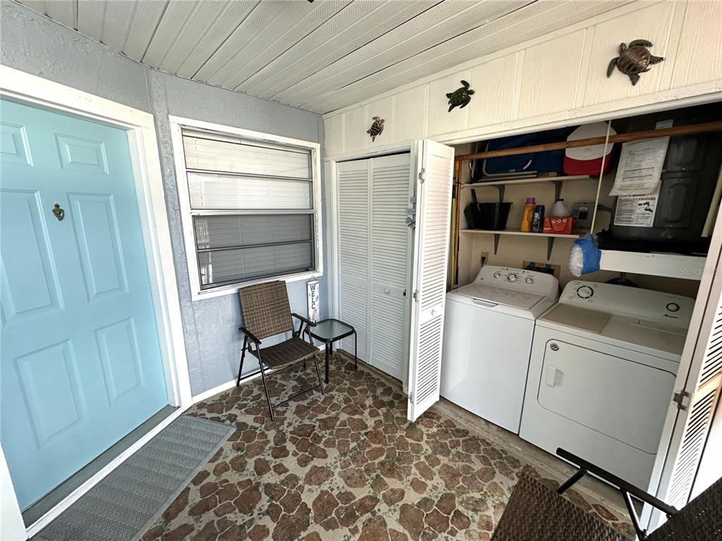 A laundry area with a washer and dryer is located on a covered patio — 3821 59TH AVENUE W UNIT 3821, BRADENTON, FL