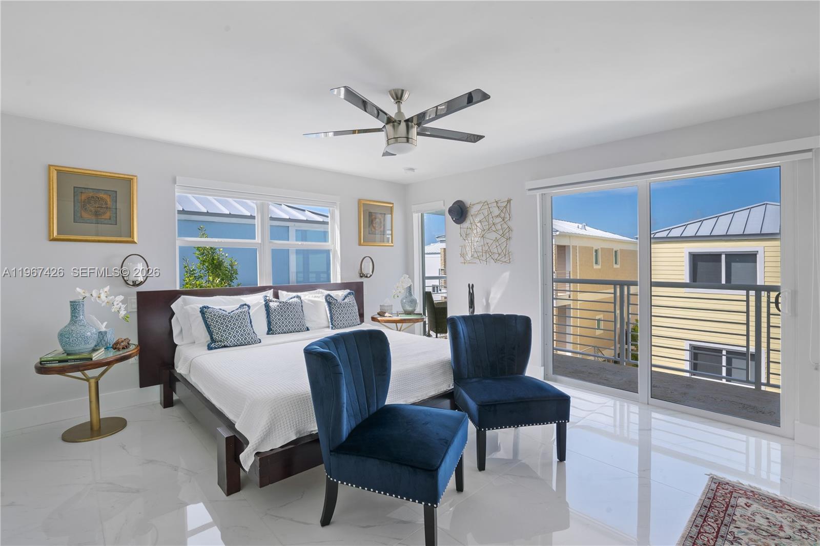 A bedroom features a bed, two blue velvet chairs, white tile floors, and a balcony — 94825 Overseas #178 # 178, Key Largo FL 33037, KEY LARGO, FL