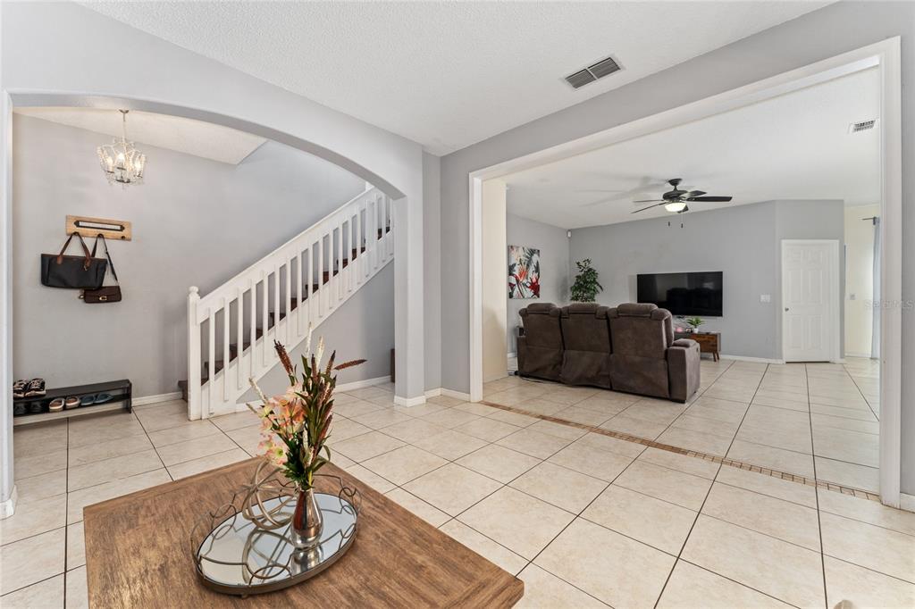 A view of a tiled entryway with a staircase leading to a living room area — 2035 ISLAND BROOK LANE, ORLANDO, FL