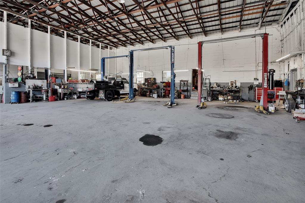 An industrial auto repair shop features concrete floors, exposed ceiling trusses, and two vehicle lifts — 309 S FLORIDA AVENUE, DELAND, FL