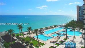 An elevated view of a swimming pool area overlooking the ocean with palm trees — 1830 S Ocean Dr # 2503, Hallandale Beach FL 33009, HALLANDALE BEACH, FL