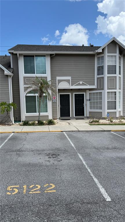 A two-story residential building features gray siding, two black front doors, and a palm tree — 505 SUN RIDGE PLACE UNIT 122, ALTAMONTE SPRINGS, FL