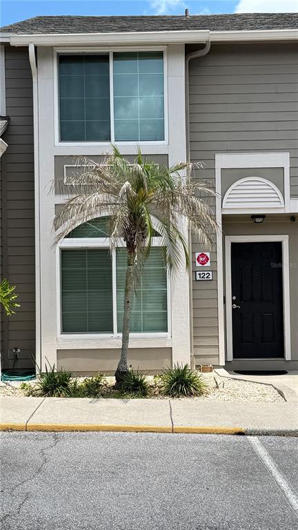 The exterior of a two-story townhouse features a palm tree in front of a window — 505 SUN RIDGE PLACE UNIT 122, ALTAMONTE SPRINGS, FL
